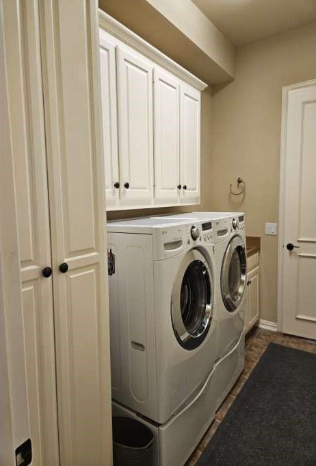 washroom with cabinets and washing machine and dryer