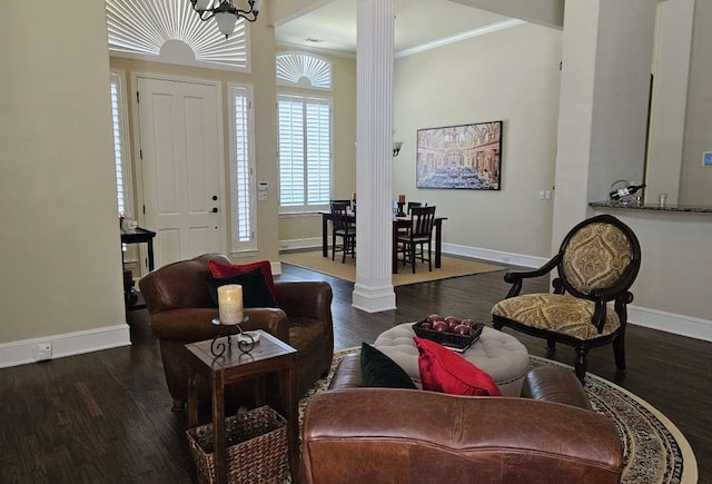 living room with dark hardwood / wood-style flooring, decorative columns, and crown molding