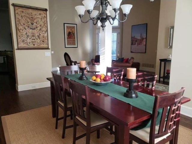 dining area with wood-type flooring and a chandelier