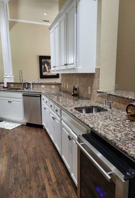 kitchen featuring sink, dishwasher, white cabinets, and dark hardwood / wood-style flooring