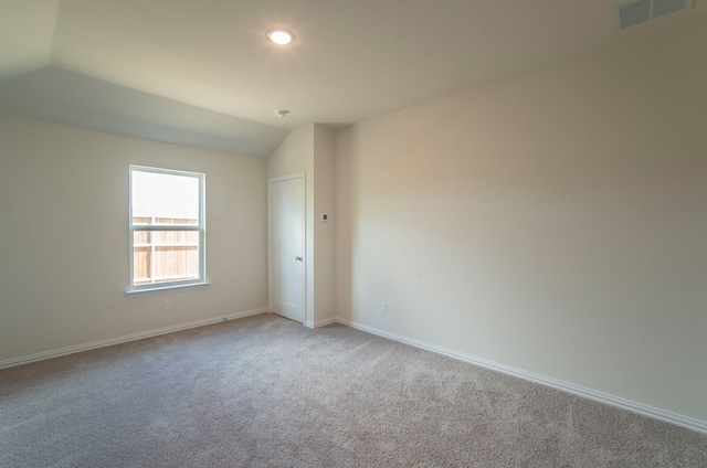 unfurnished room featuring carpet flooring and vaulted ceiling