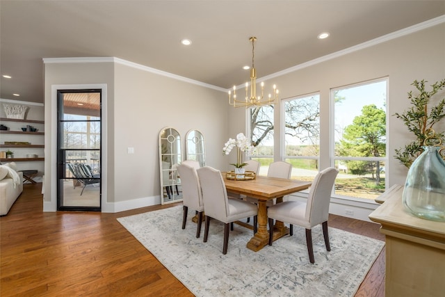 dining room with wood-type flooring, ornamental molding, and a chandelier