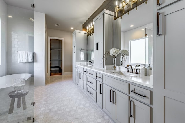 bathroom with double vanity, tile flooring, and a bathing tub