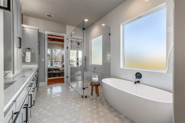 bathroom featuring a bath to relax in, vanity, and tile floors