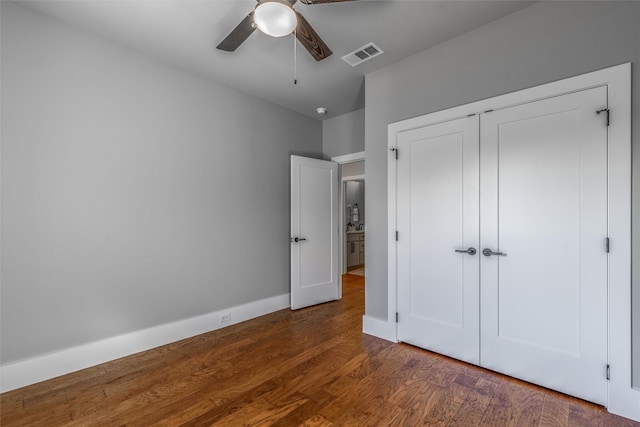 unfurnished bedroom featuring dark hardwood / wood-style flooring, a closet, and ceiling fan