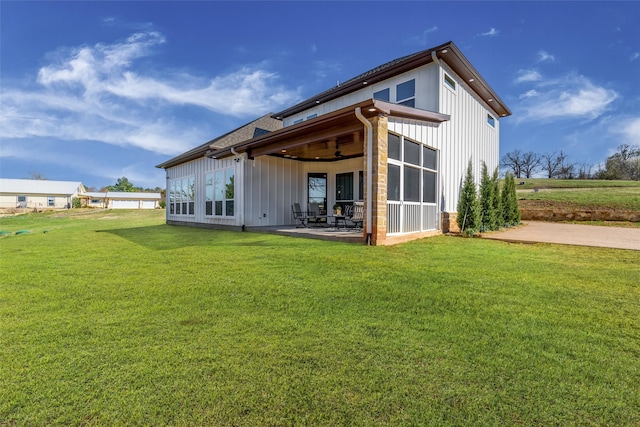 rear view of property featuring a yard, ceiling fan, and a patio