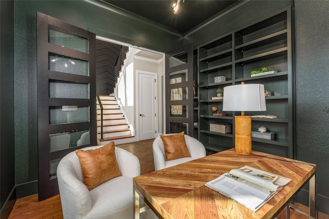 interior space featuring ornamental molding, built in shelves, and wood-type flooring