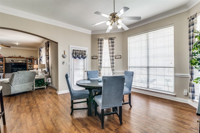 dining space featuring dark wood-type flooring, ceiling fan, and crown molding