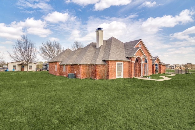 exterior space featuring central AC and a front lawn