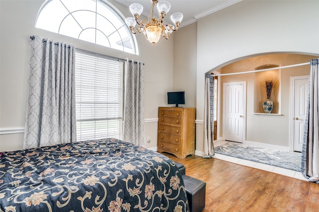 bedroom with crown molding, a chandelier, light tile floors, and multiple windows