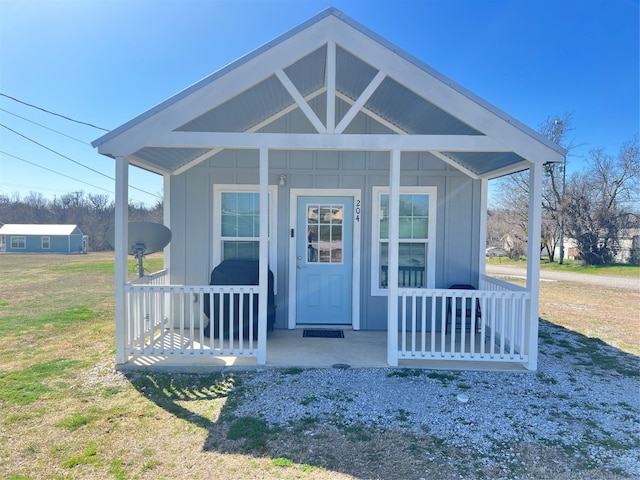 view of front of house featuring covered porch and a front lawn