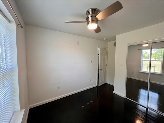 unfurnished bedroom featuring ceiling fan, dark wood-type flooring, and a closet