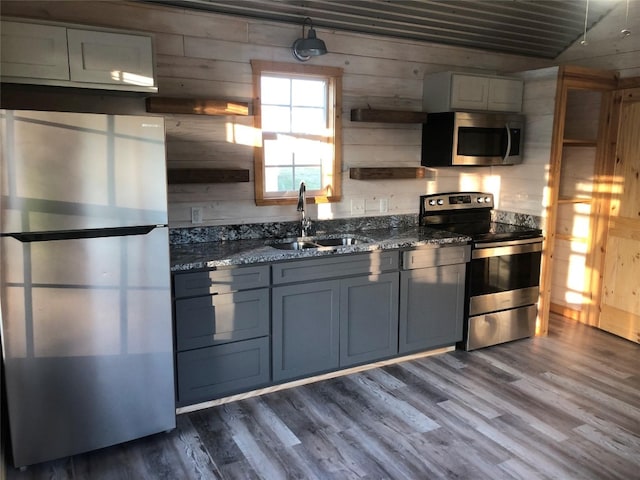 kitchen with appliances with stainless steel finishes, sink, gray cabinetry, and dark hardwood / wood-style flooring