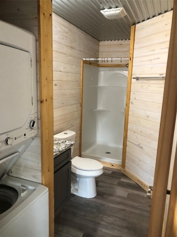 bathroom featuring hardwood / wood-style flooring, wooden walls, vanity, and toilet