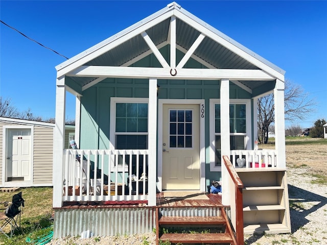 view of front of house with a storage shed and covered porch