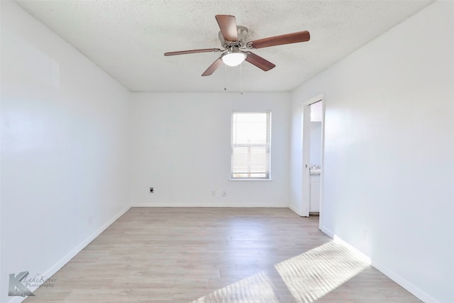 empty room with a textured ceiling, ceiling fan, and light wood-type flooring