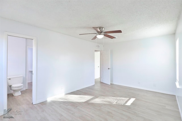 empty room with ceiling fan, a textured ceiling, and light hardwood / wood-style flooring