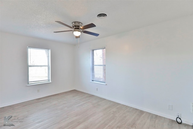 spare room featuring a textured ceiling, ceiling fan, and light wood-type flooring