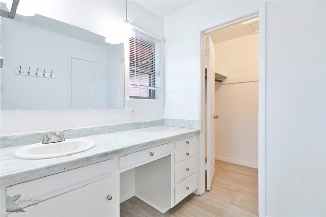 bathroom with large vanity and hardwood / wood-style floors