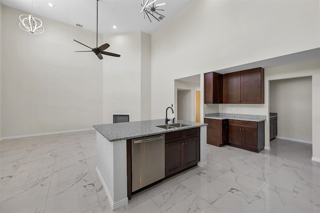 kitchen featuring ceiling fan with notable chandelier, high vaulted ceiling, sink, an island with sink, and stainless steel dishwasher