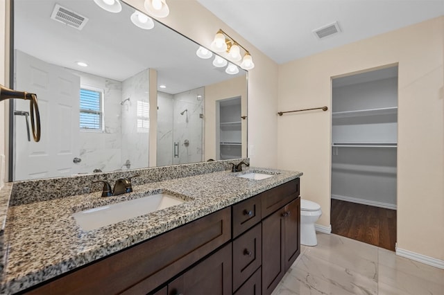 bathroom featuring an enclosed shower, double sink, tile floors, toilet, and large vanity