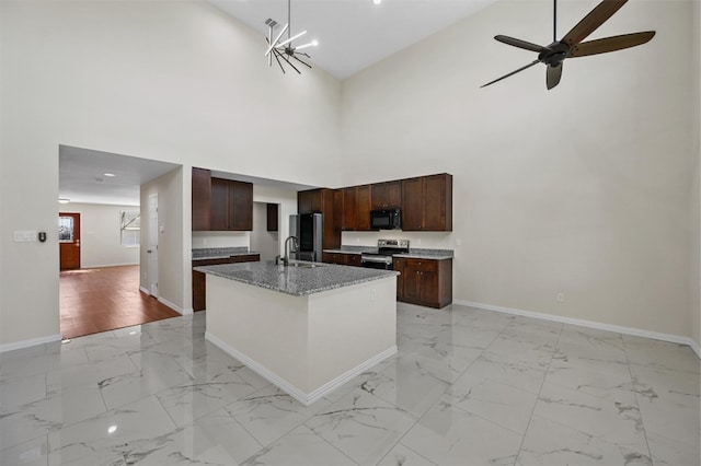 kitchen with light tile floors, a center island with sink, high vaulted ceiling, and appliances with stainless steel finishes