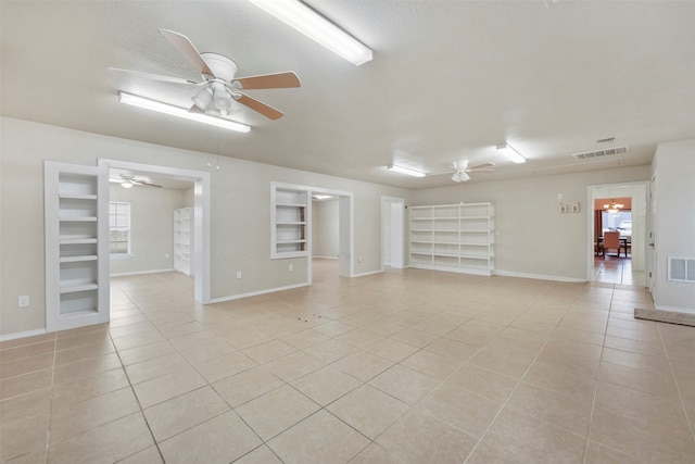 unfurnished living room featuring a textured ceiling, built in features, light tile patterned floors, and ceiling fan