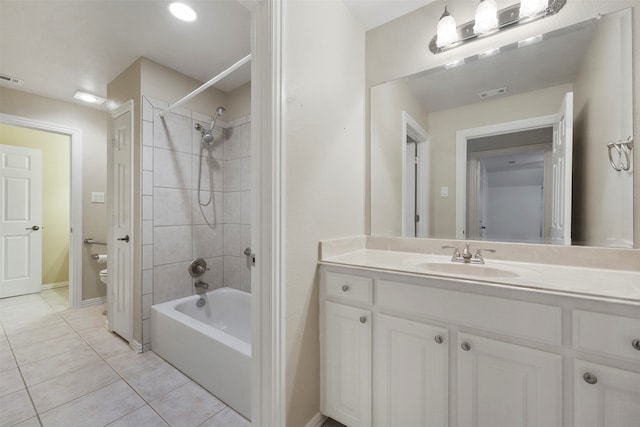 full bathroom featuring vanity, tiled shower / bath, tile patterned flooring, and toilet