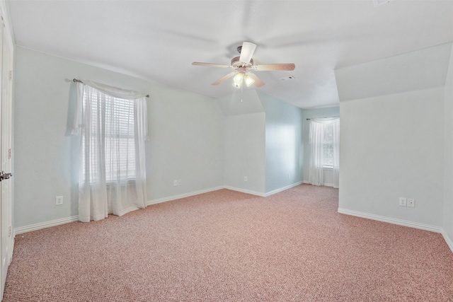 carpeted empty room with lofted ceiling, a healthy amount of sunlight, and ceiling fan