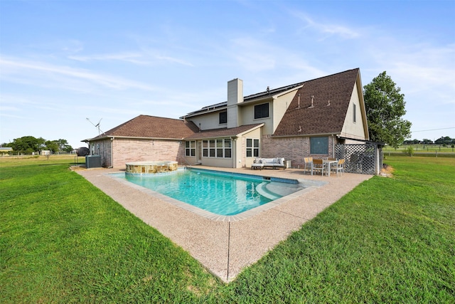 view of pool with a yard, pool water feature, a patio, and central AC