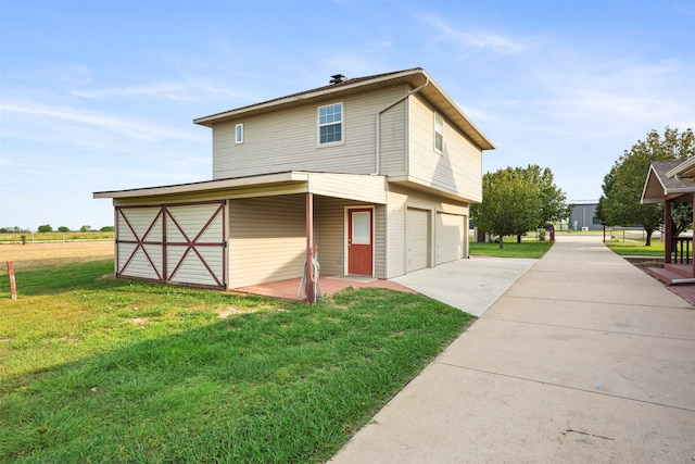 back of house with a garage and a lawn