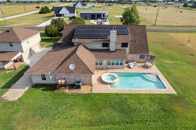 view of swimming pool with an in ground hot tub, central AC unit, a patio area, and a yard