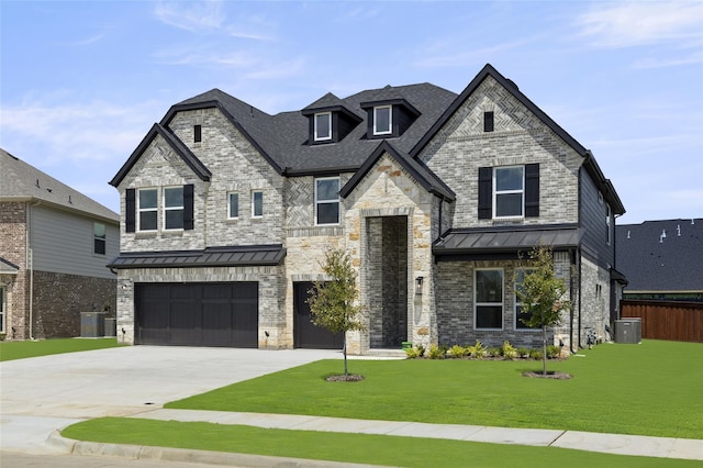 view of front of house with a garage, a front yard, and central AC