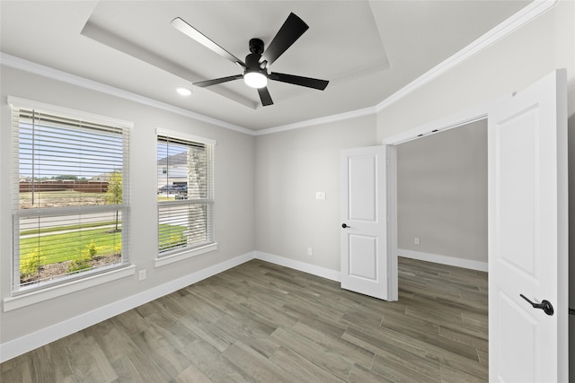 spare room with ceiling fan, crown molding, wood-type flooring, and a tray ceiling