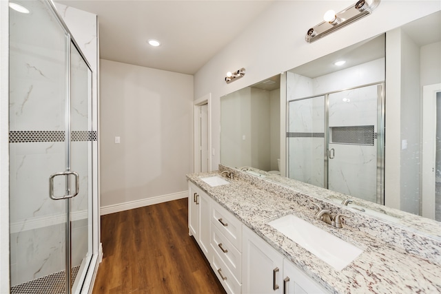 bathroom with hardwood / wood-style flooring, an enclosed shower, vanity, and toilet