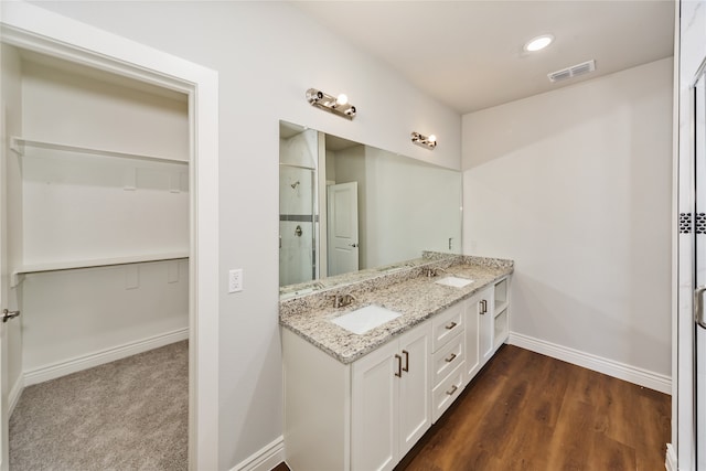 bathroom with vanity, hardwood / wood-style floors, and a shower with door