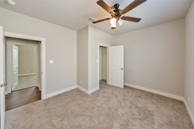 unfurnished bedroom featuring ceiling fan, a closet, and light colored carpet