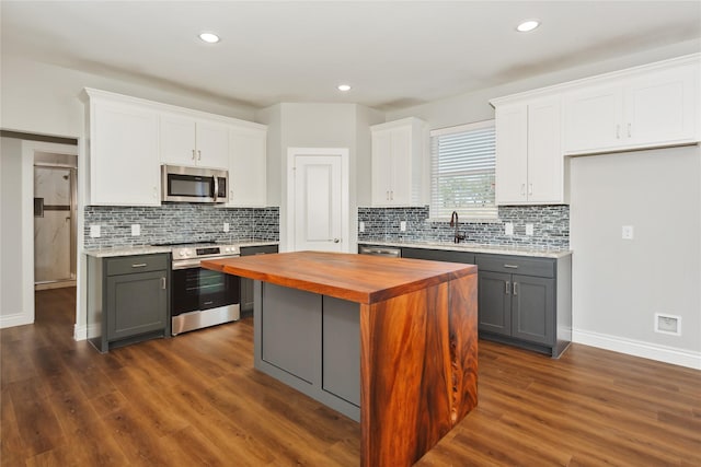 kitchen with appliances with stainless steel finishes, white cabinetry, and gray cabinets