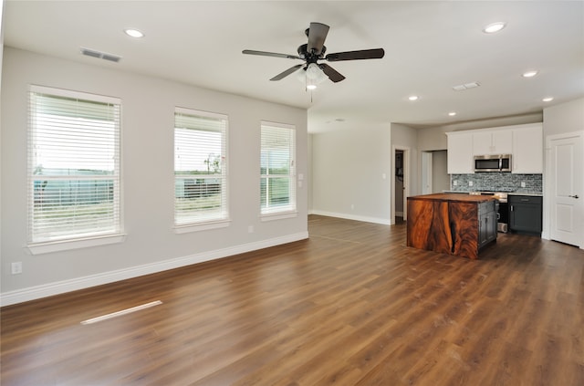 kitchen featuring ceiling fan, white cabinets, backsplash, stainless steel appliances, and dark hardwood / wood-style floors