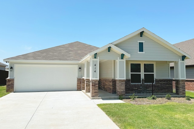 craftsman-style home with a garage, a front lawn, and covered porch