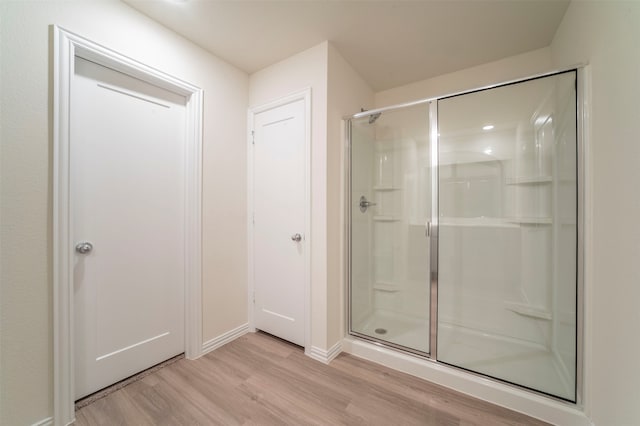 bathroom featuring walk in shower and hardwood / wood-style flooring