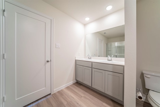 bathroom with toilet, hardwood / wood-style flooring, and double vanity