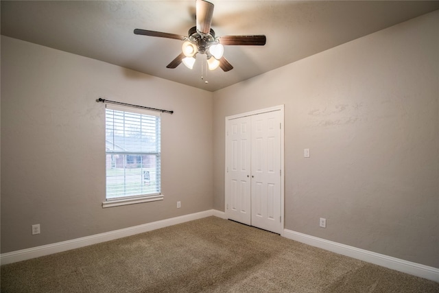 carpeted spare room featuring ceiling fan