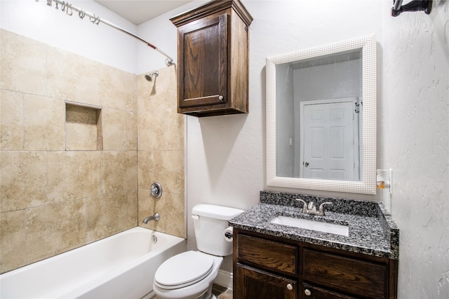 full bathroom featuring tiled shower / bath combo, toilet, and vanity