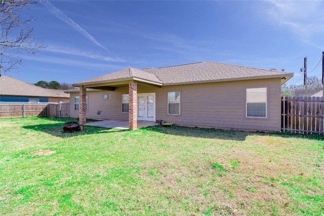 back of property with a yard and a patio