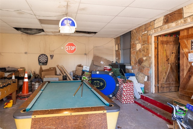 game room featuring billiards, concrete flooring, and a drop ceiling