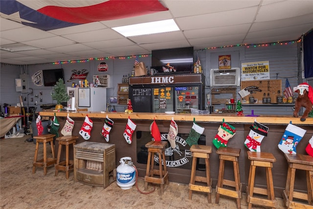 bar featuring a workshop area, a paneled ceiling, a wall mounted AC, and butcher block countertops