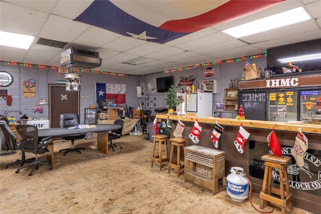 miscellaneous room featuring a paneled ceiling and a workshop area