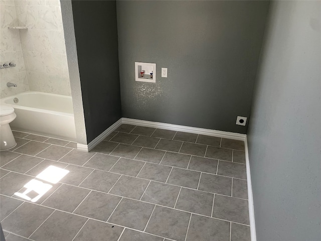 bathroom featuring washtub / shower combination, tile floors, and toilet