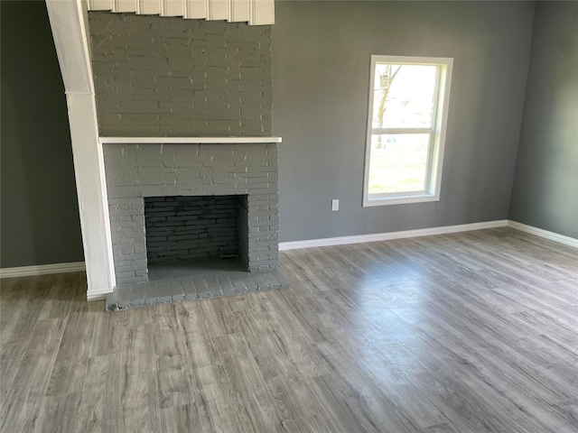 unfurnished living room with hardwood / wood-style flooring and a fireplace